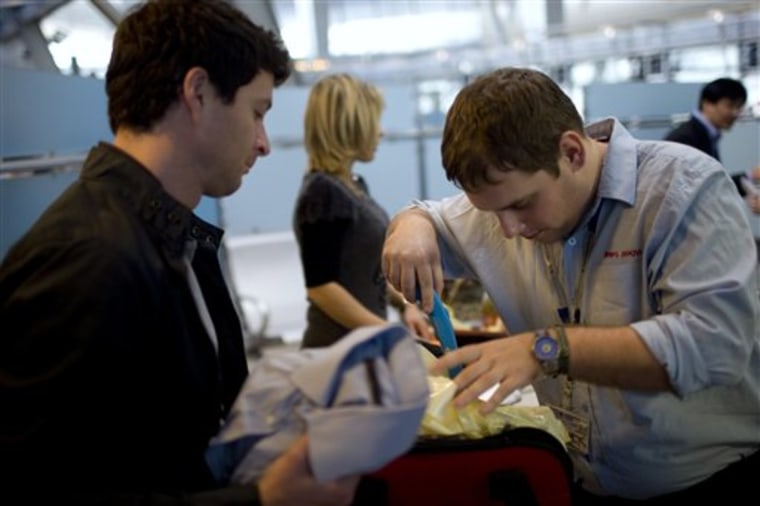 A passenger has his luggage checked by security personnel at Tel Aviv's Ben Gurion airport in November, 2010.